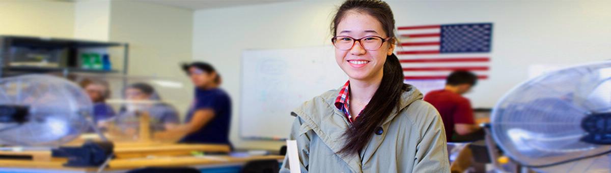 A student stands in front of an engineering lab table in a Pima engineering lab